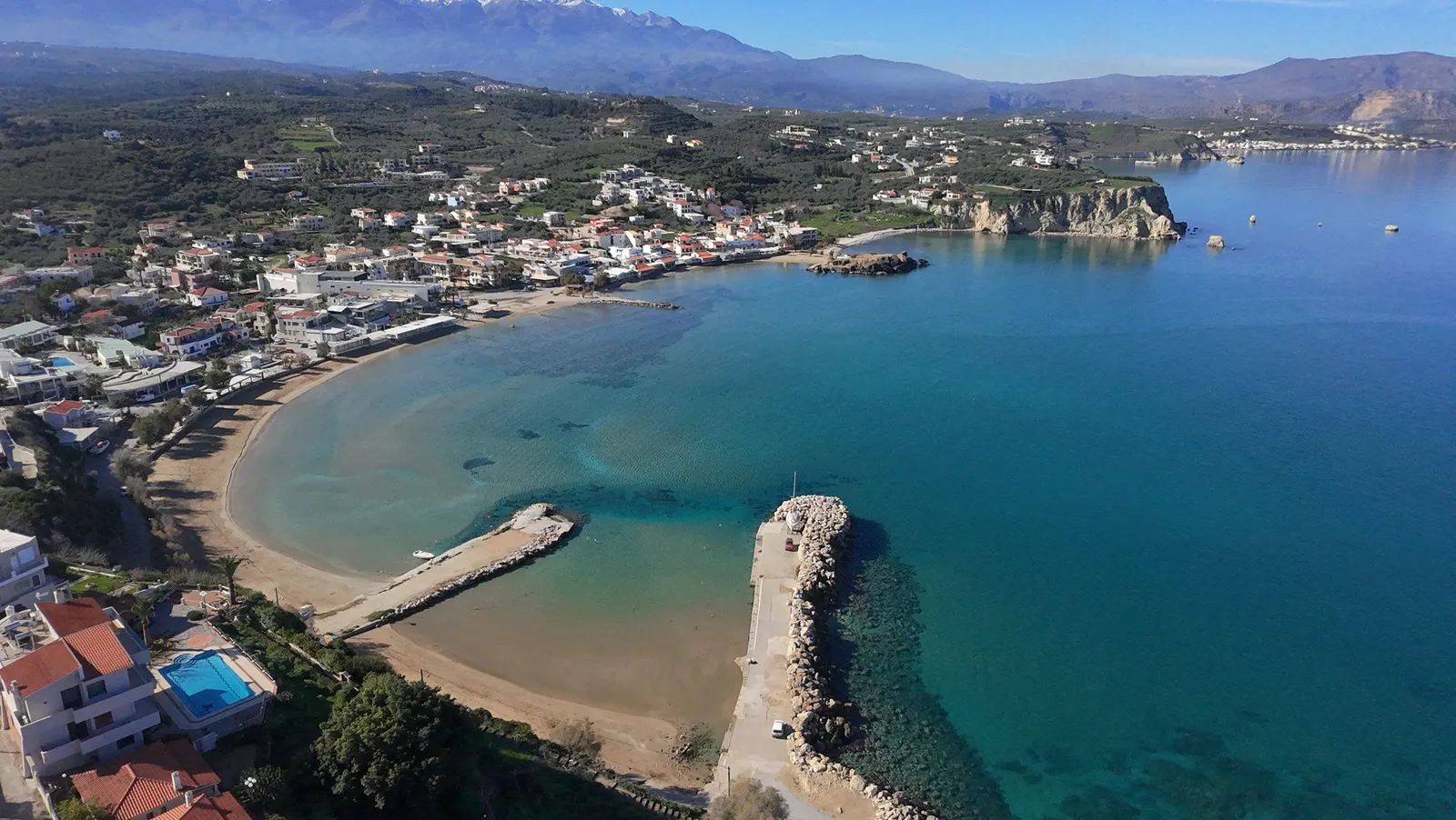 Coastal view of Almyrida, featuring deep turquoise waters and rugged scrubland meeting the Mediterranean Sea.