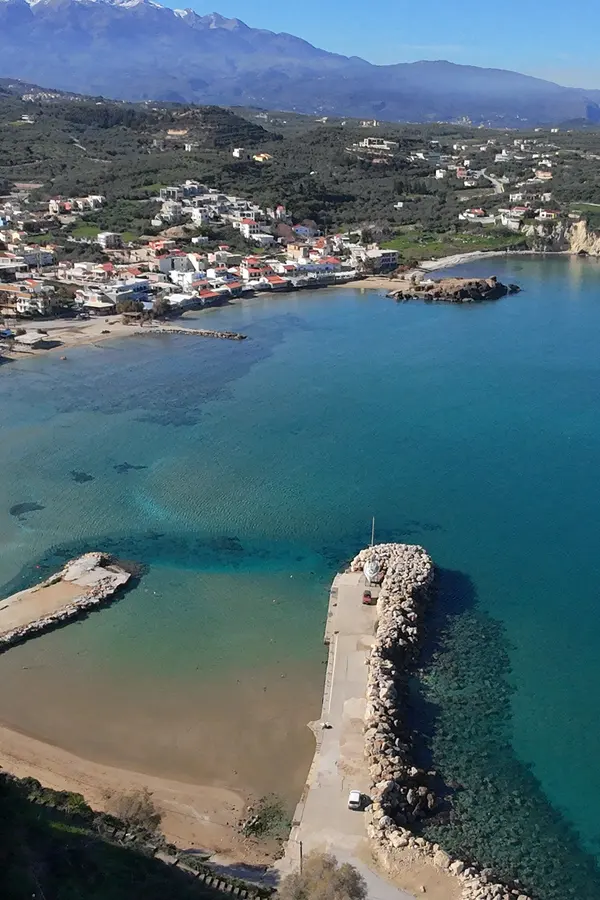 Coastal view of Almyrida, featuring deep turquoise waters and rugged scrubland meeting the Mediterranean Sea.