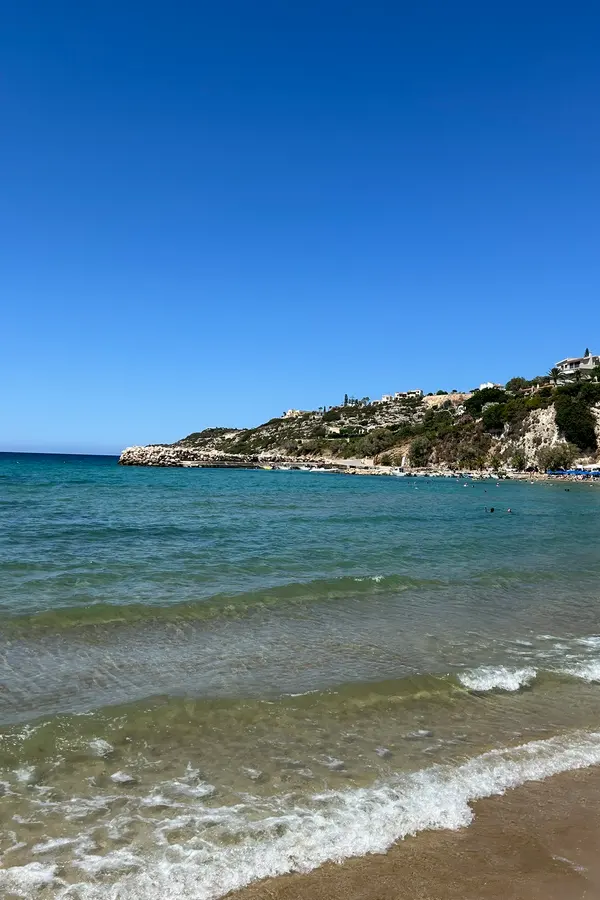 Clear turquoise waters meeting the rugged coastal landscape of Almyrida, Crete.