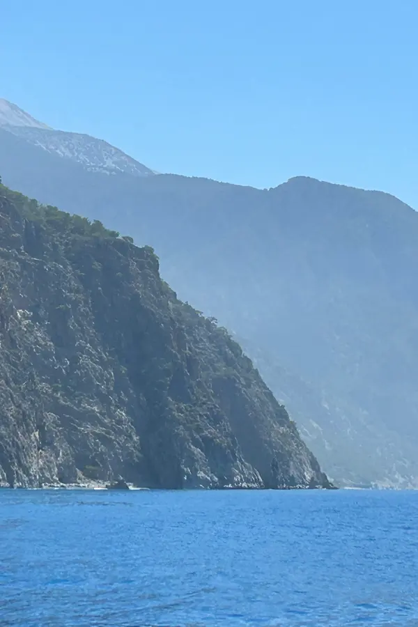 Clear turquoise water meeting the rugged headland of Fournoti cape on the dramatic Cretan coastline.