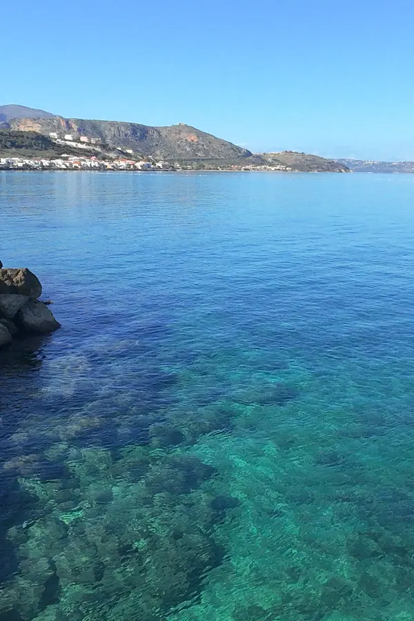 Clear blue waters meeting the rugged coastline near Kalyves village in Crete.