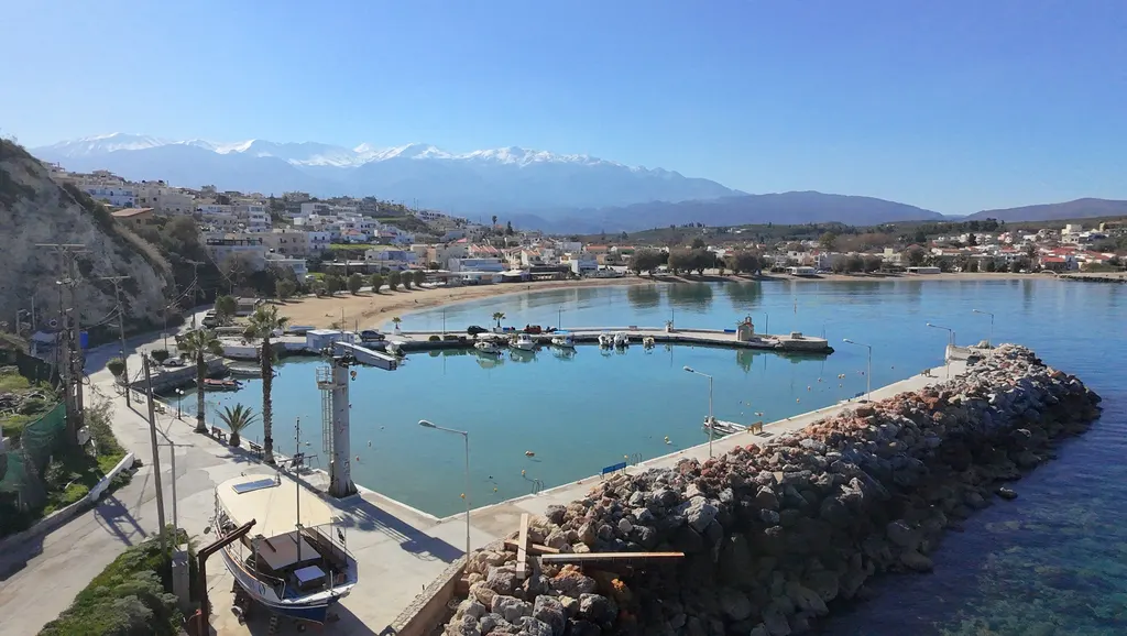 Coastal village of Kalyves with white-washed houses overlooking the crystal blue Aegean Sea.
