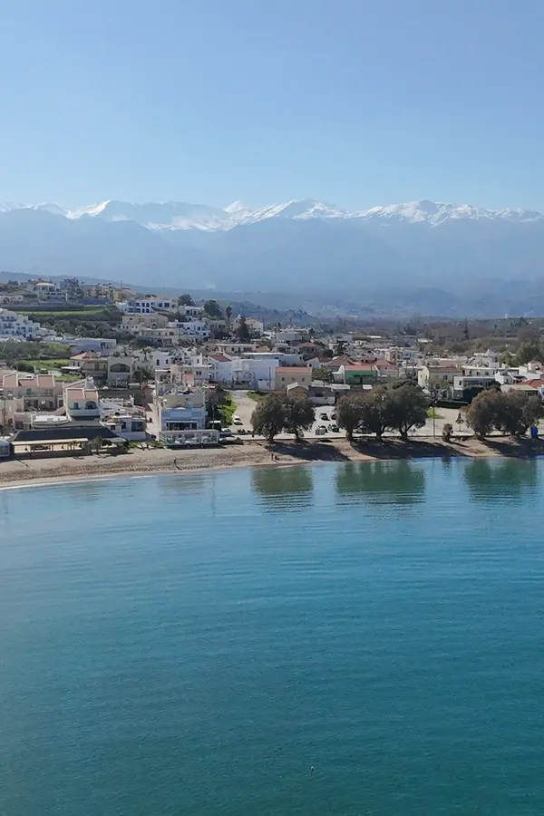 Tranquil bay scene showing the clear Aegean Sea and coastal cliffs of Kalyves, Crete.