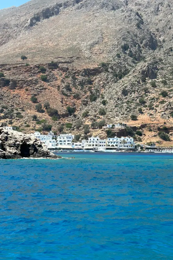 Traditional stone village architecture meeting the clear turquoise waters of Loutro bay, Crete.