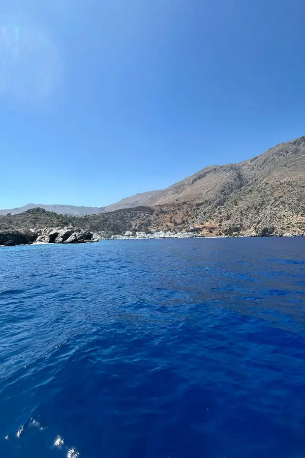 White-washed houses and calm turquoise waters in the sheltered harbor of Loutro, Crete.