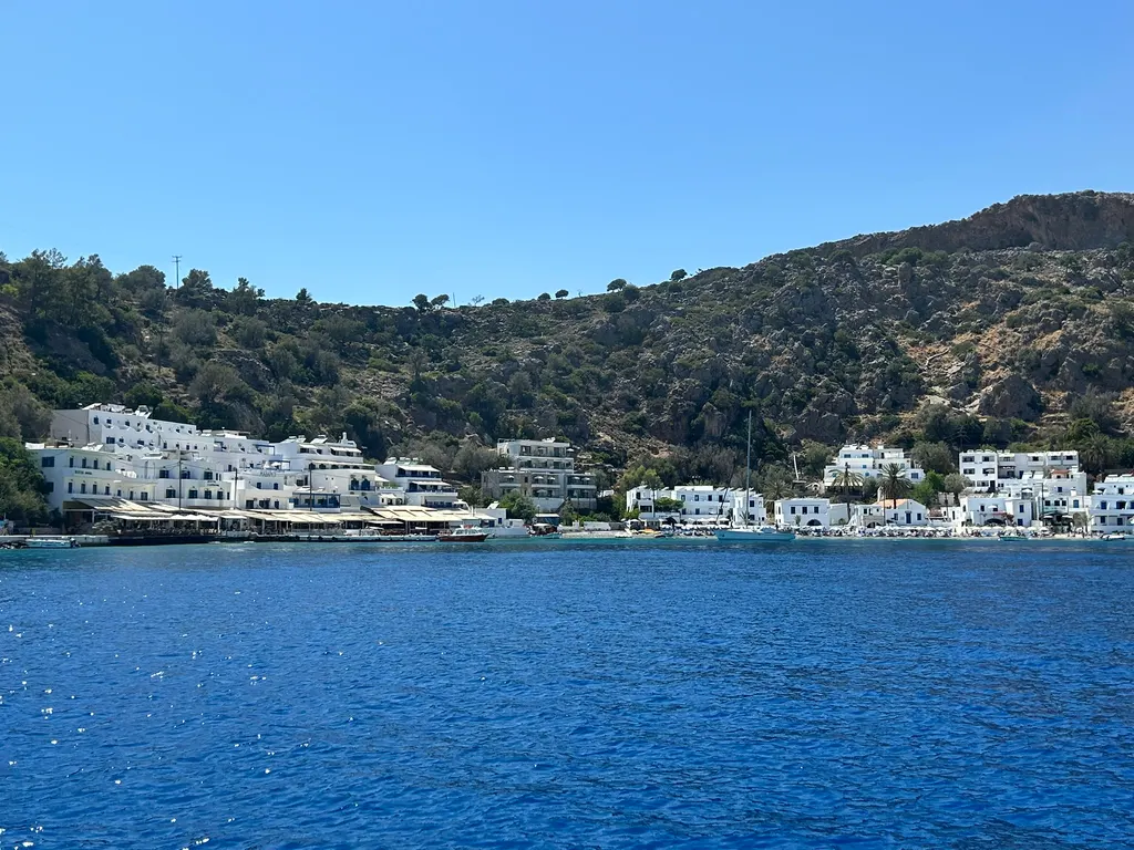 Quaint harbor and traditional white houses of Loutro village, set against the deep blue waters of the southern Cretan coast.