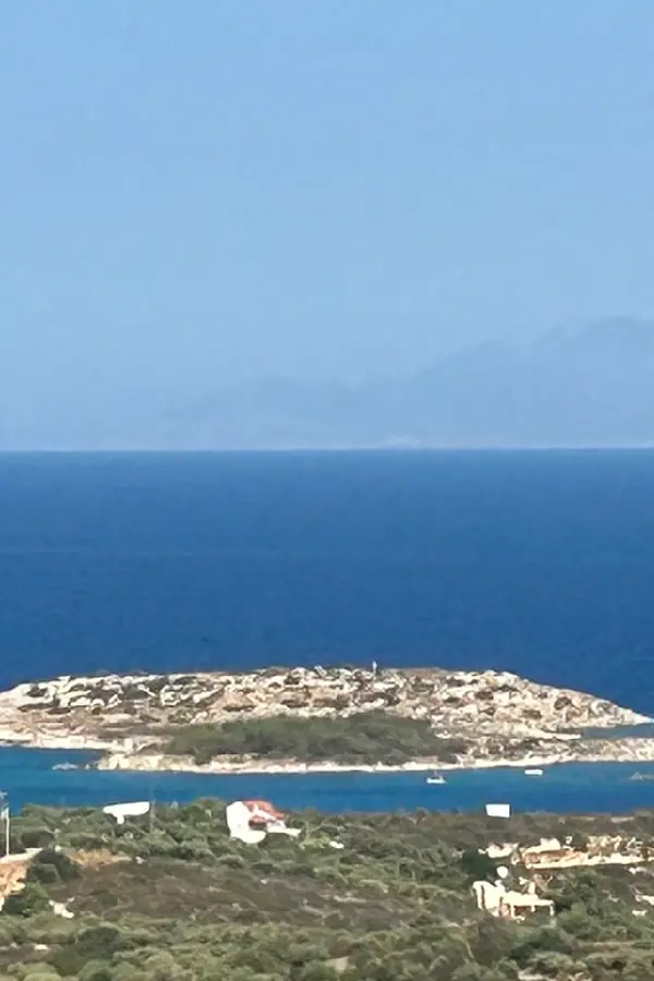 Coastal view of the village of Marathi, featuring traditional architecture and the deep blue Aegean Sea.