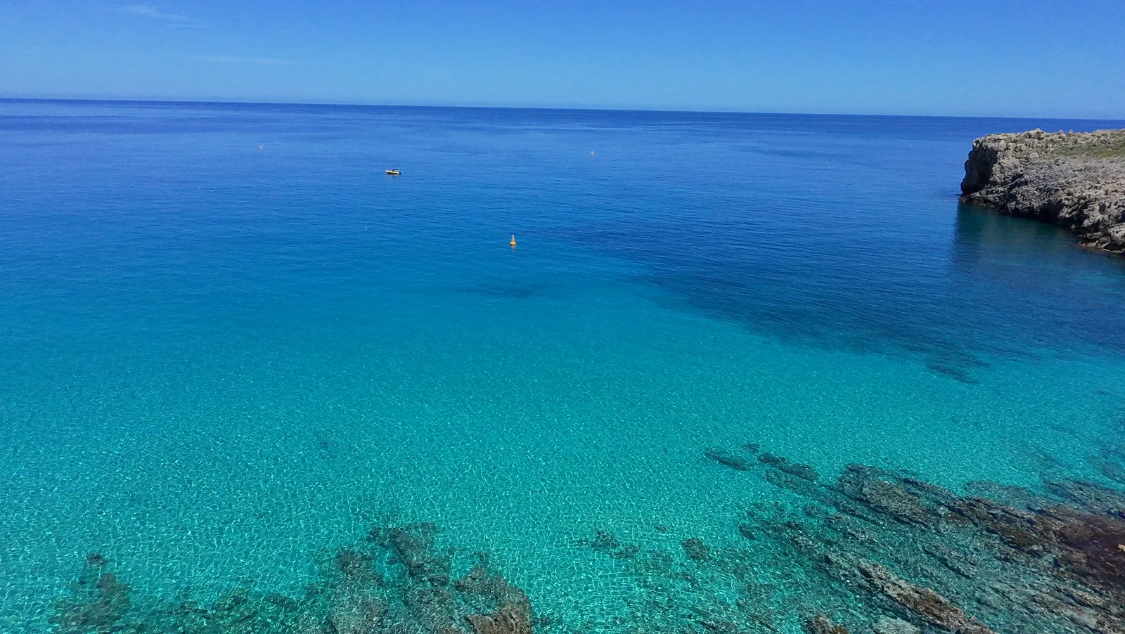 Turquoise waters frame the rugged coastline and small coves of Ombrosgialos, Crete.