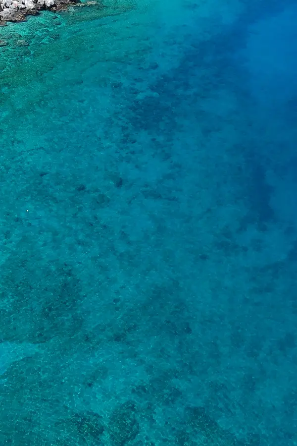 Sheltered coves and clear turquoise waters define the beautiful landscape of Ombrosgialos in Crete.