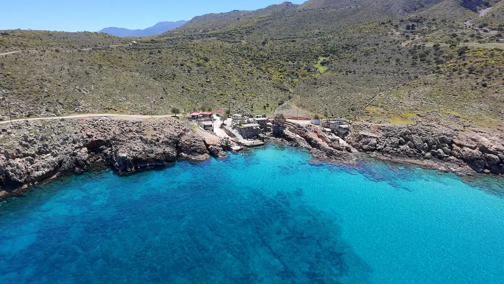 Crystal clear turquoise waters and secluded coves at Ombrosgialos, a hidden bay on the Cretan coast.