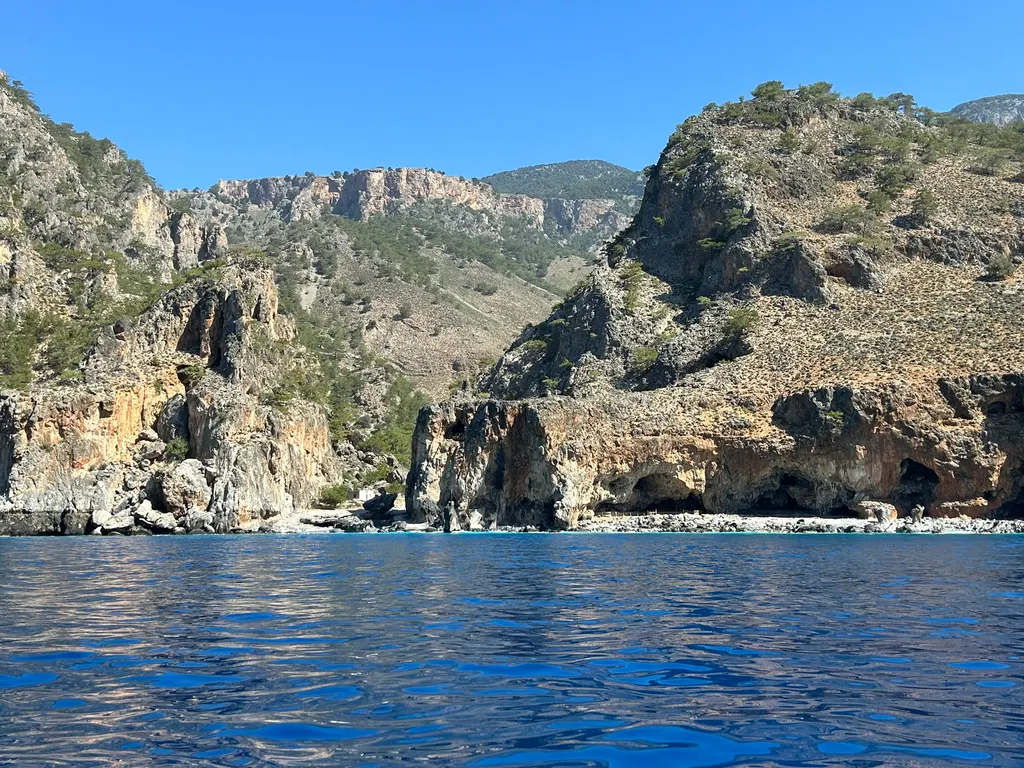 Dramatic coastal cliffs and deep azure waters surrounding the remote Tripiti cape on Crete's southern coast.