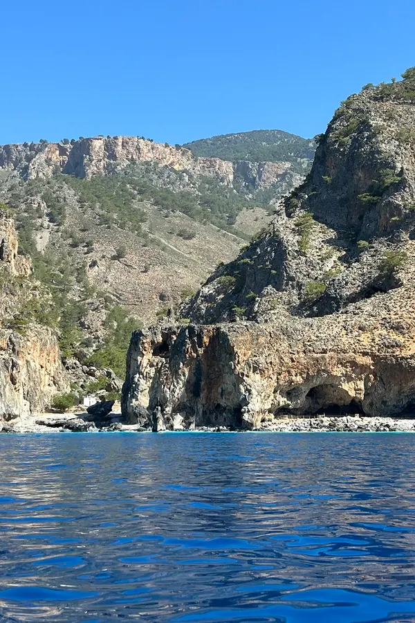 Dramatic coastal cliffs and deep azure waters surrounding the remote Tripiti cape on Crete's southern coast.