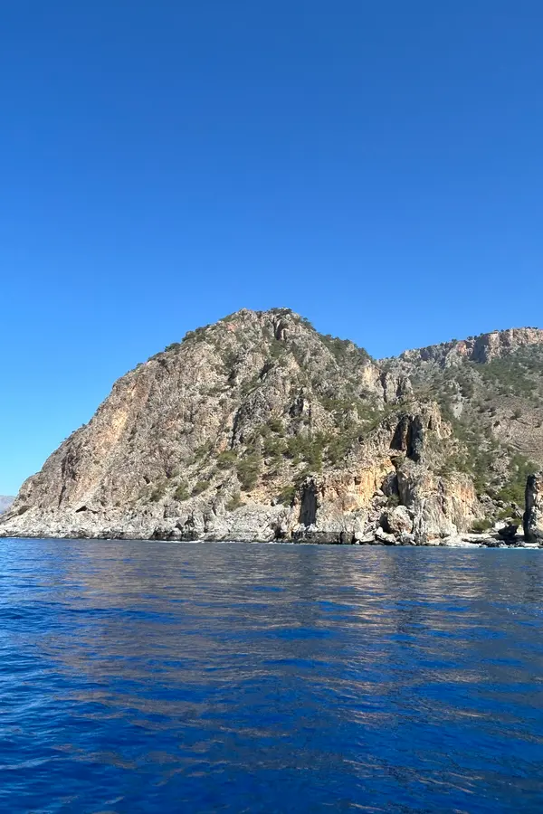 Clear blue waters and rugged rocky coastline at Tripiti, a remote cape on the southern coast of Crete.
